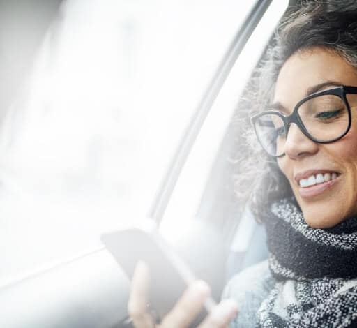 Woman in car smiling at phone
