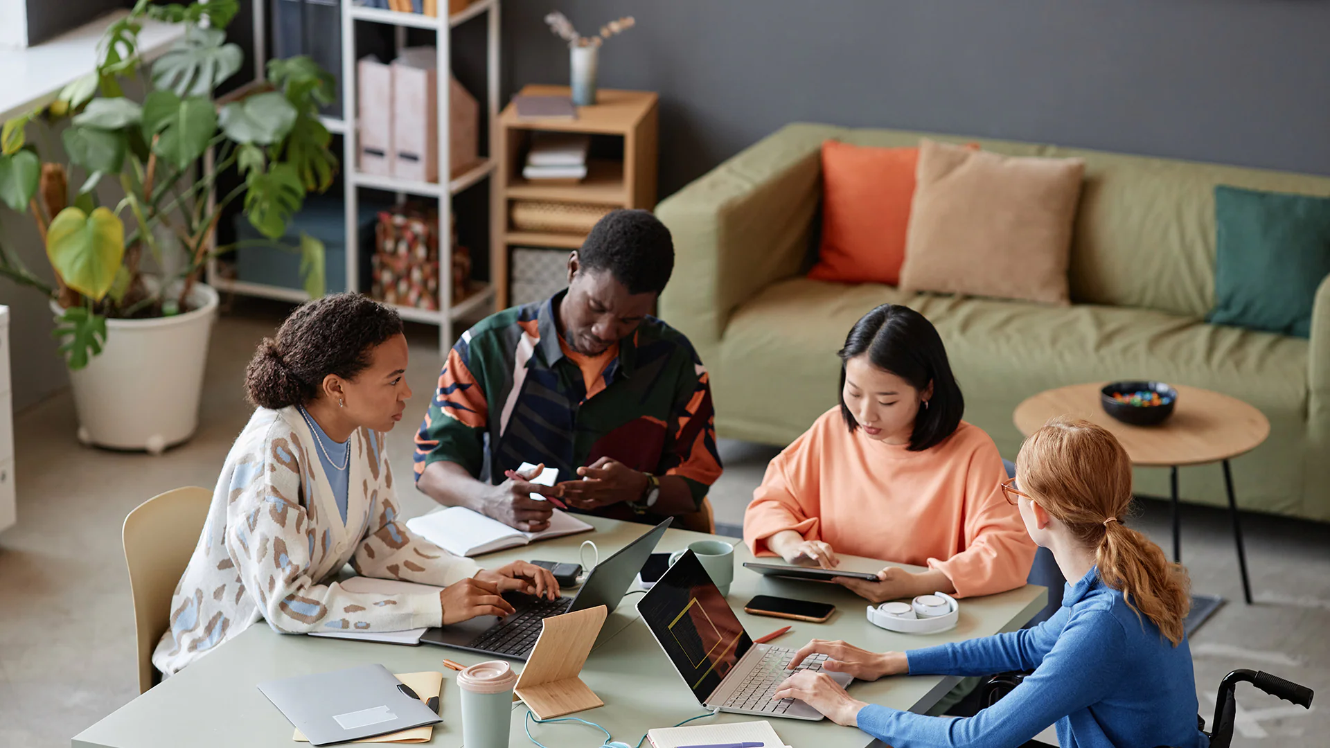 Photo of four colleagues sitting at a table must be discussing multigenerational workforce management