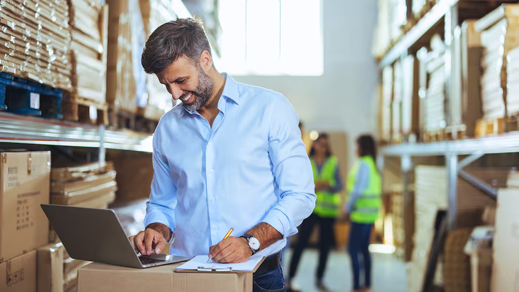 Photo of a man with a laptop in a warehouse exploring supply chain mapping