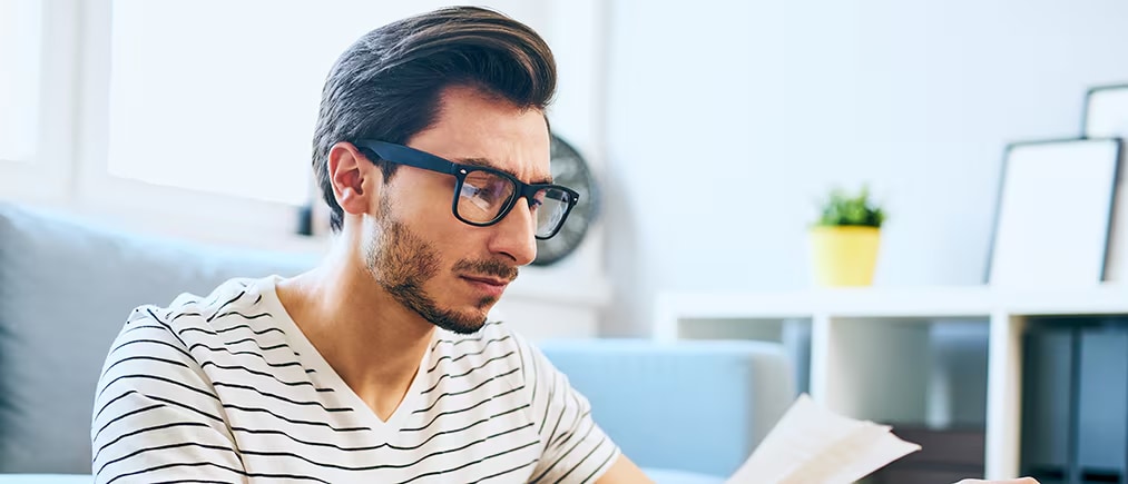 A photo of a man reviewing paperwork using a cash flow forecast template.