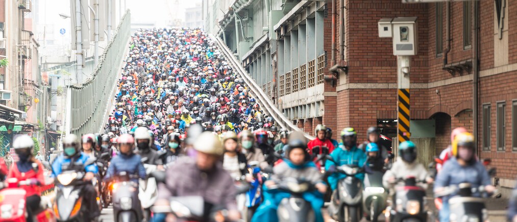 Horizontal color image of very large group of scooters riding on Taipei Streets.