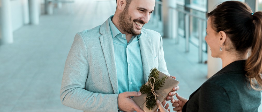 Businessman giving present to his female coworker.