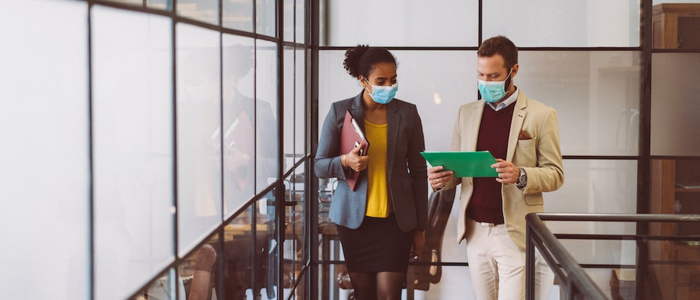 Businesspeople wearing masks in the office for illness prevention during COVID-19 pandemic