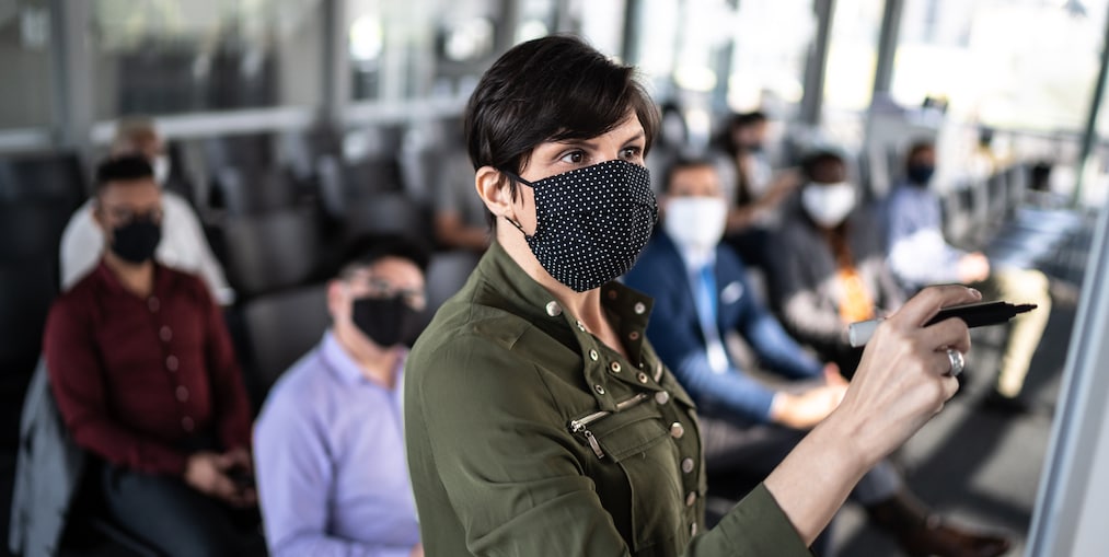 Businesswoman speaking at a business conference - with face mask