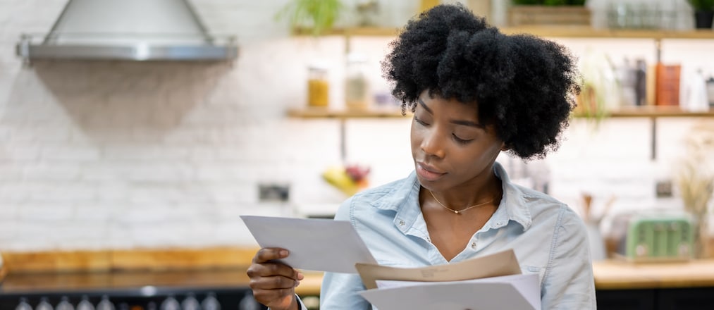 Portrait of a black woman at home checking the mail – lifestyle concepts