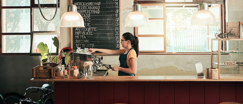 Shot of a young barista working in her coffee shop