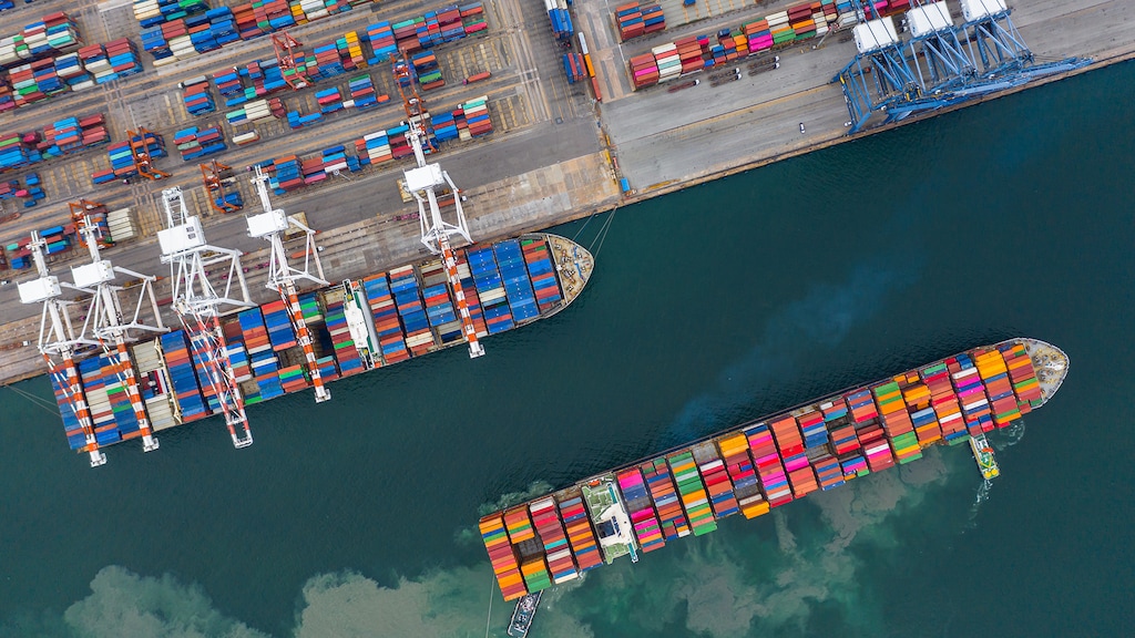 Aerial view cargo ship terminal, Unloading crane of cargo ship terminal, Aerial view industrial port with containers and container ship.