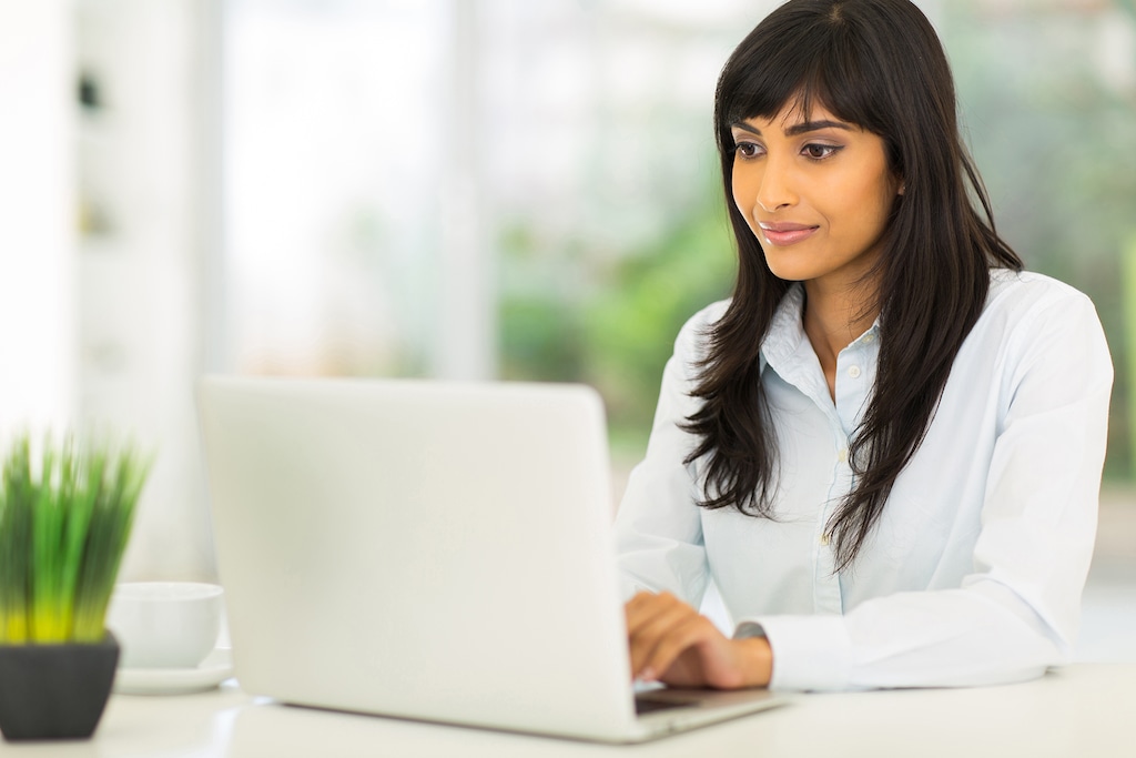 pretty indian businesswoman using computer in office; Shutterstock ID 203106901; job_number:871-20; project:Code of Conduct; client:onbrand