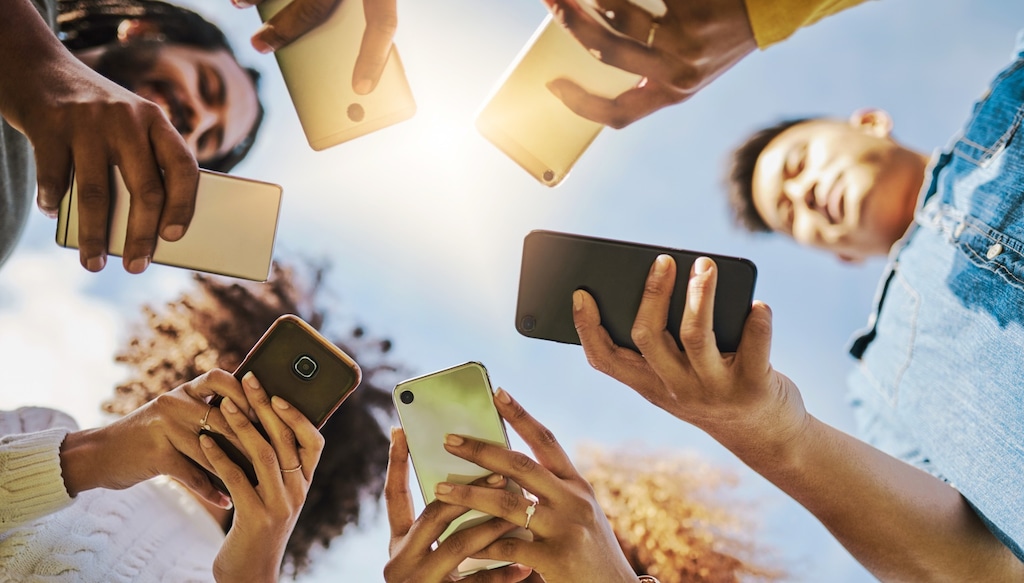 Group of people holding phones, shot from below