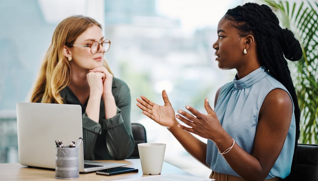 two employees having a discussion over coffee