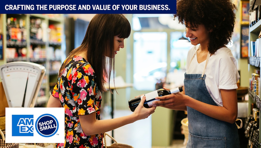 employee and customer looking at bottle of wine in store