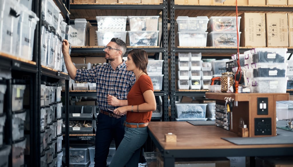 Employees looking at stock in warehouse