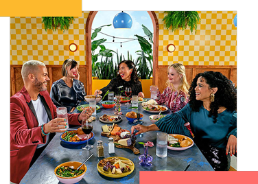 A group of five friends gathered around a table enjoying a meal