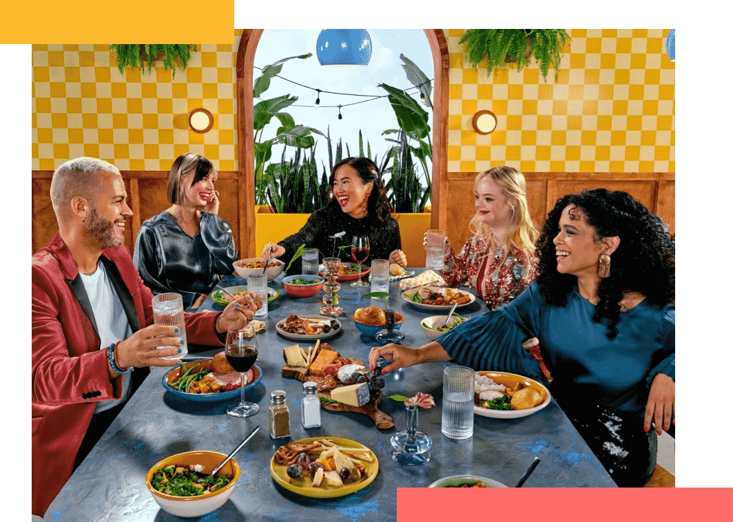 A group of five friends gathered around a table enjoying a meal