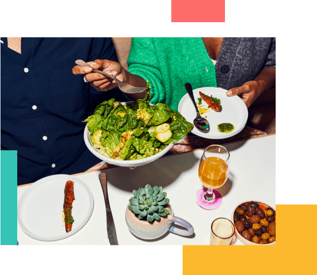 People at dinner grabbing a salad to share